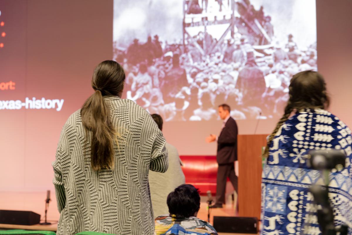 people standing near chairs and on a stage