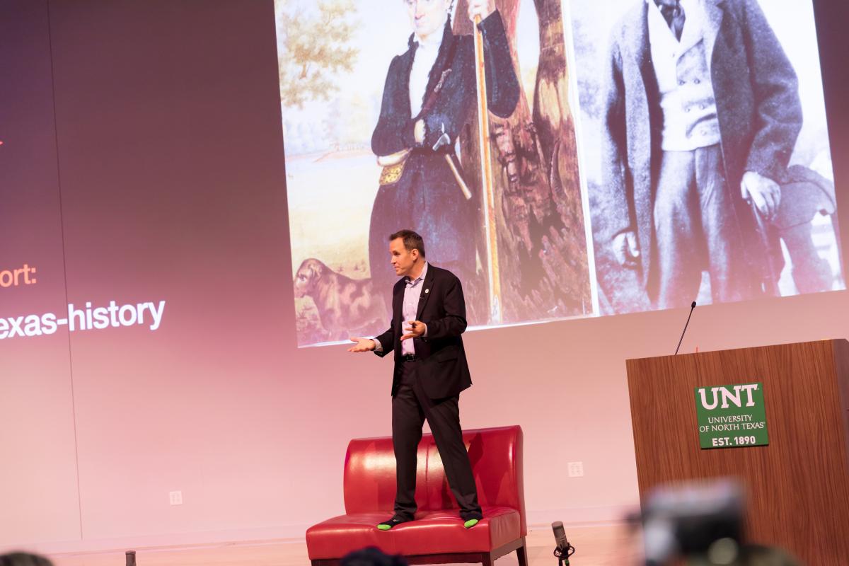 man standing on a chair on a stage