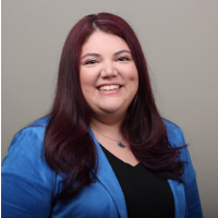 smiling woman with brown hair wearing a blue jacket