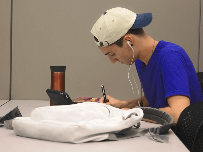 man sitting at a table writing